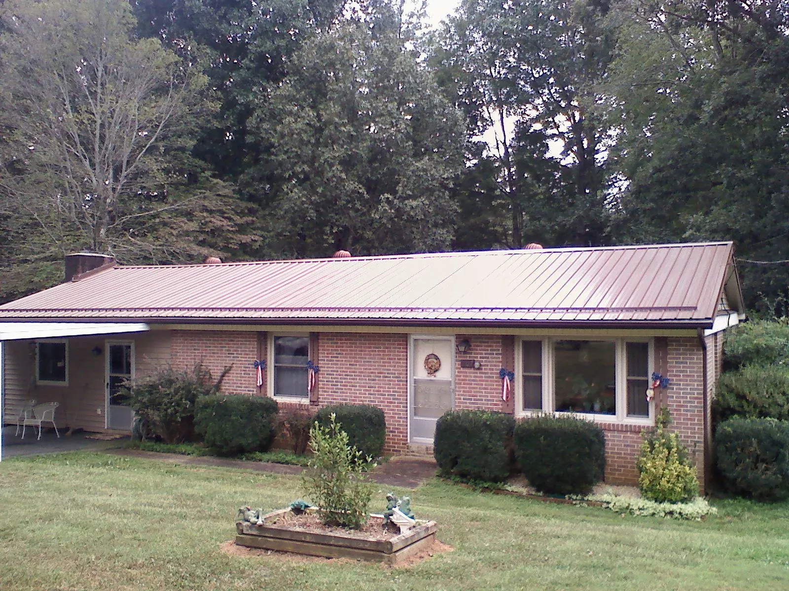 Bronze metal roof on a brick ranch home with a carport in Grand Canyon