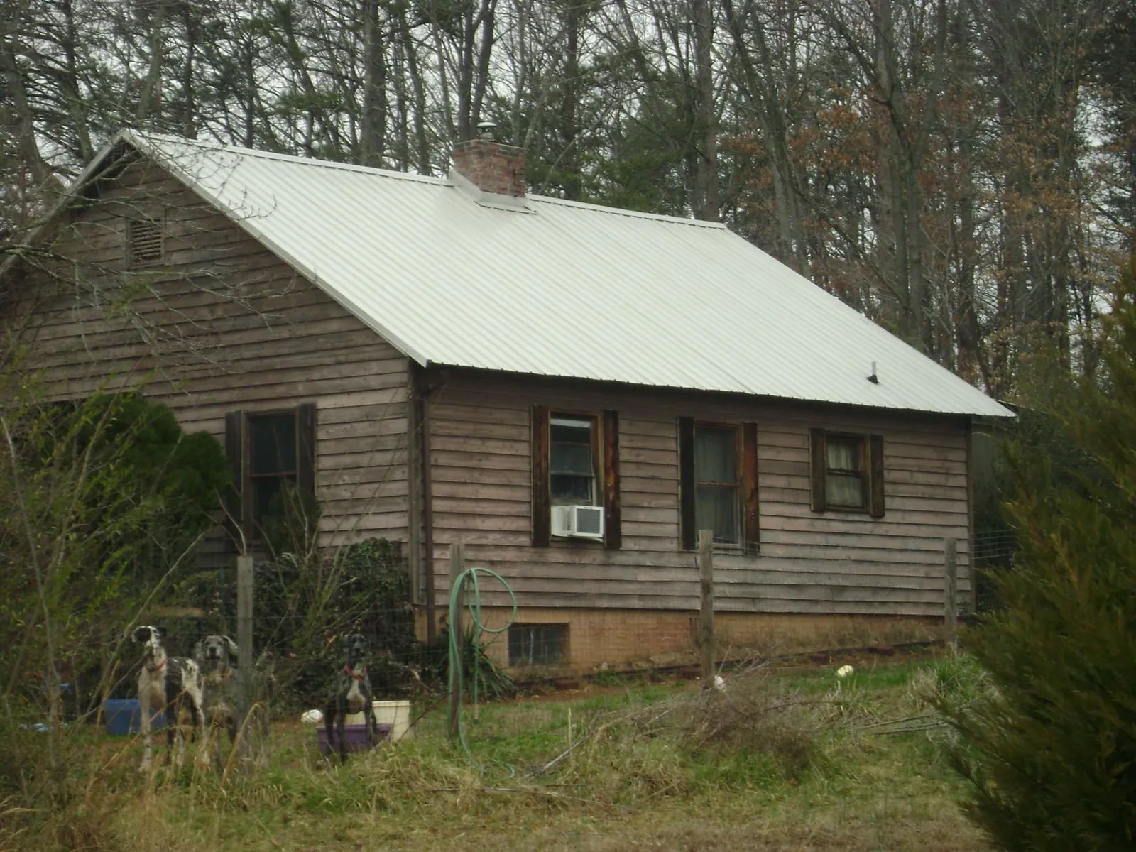 White metal roof on an old wood sided farmhouse, from a Metal Roof Installation job in Grand Canyon